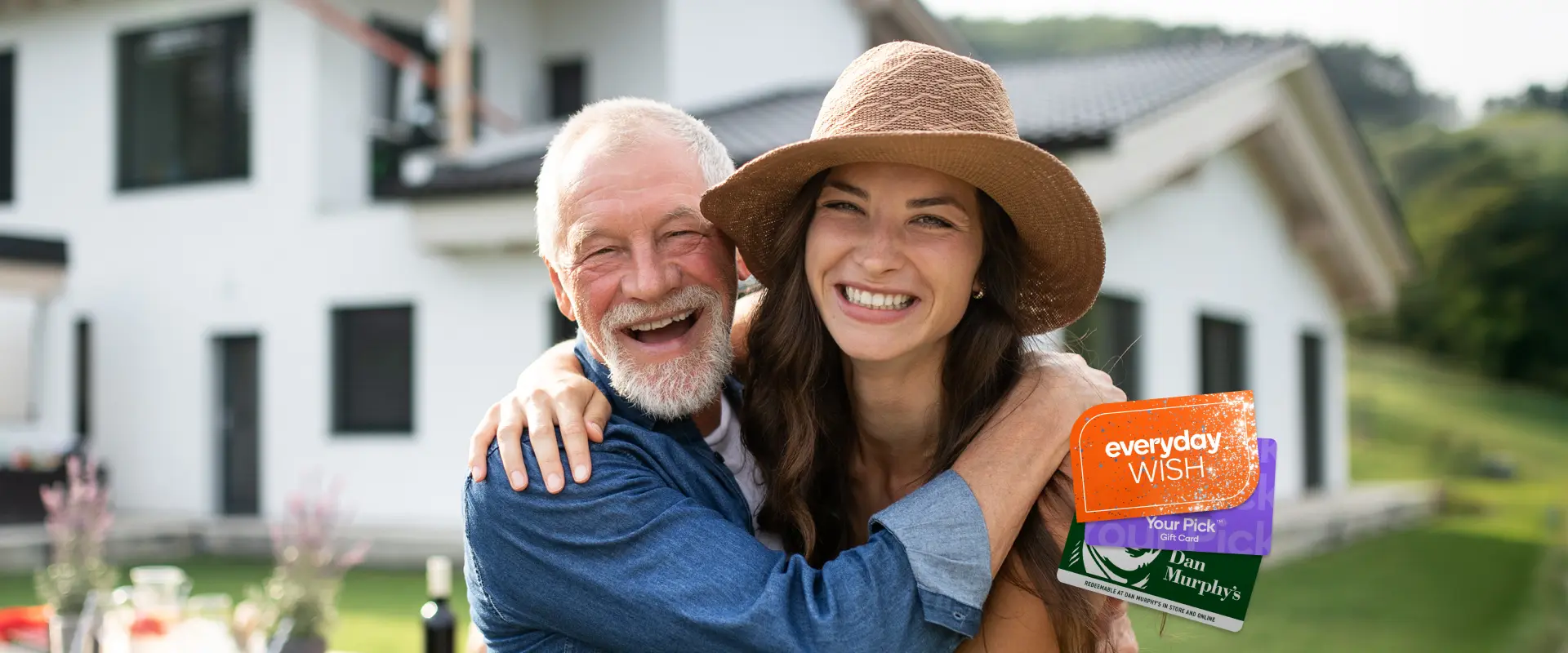 A smiling young woman wearing a hat hugs her dad outdoors in front of a house, alongside a graphic showing everyday WISH, Your Pick, and Dan Murphy's gift cards.